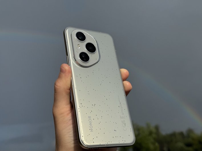 Honor 400 Pro под дождем на фоне радуги