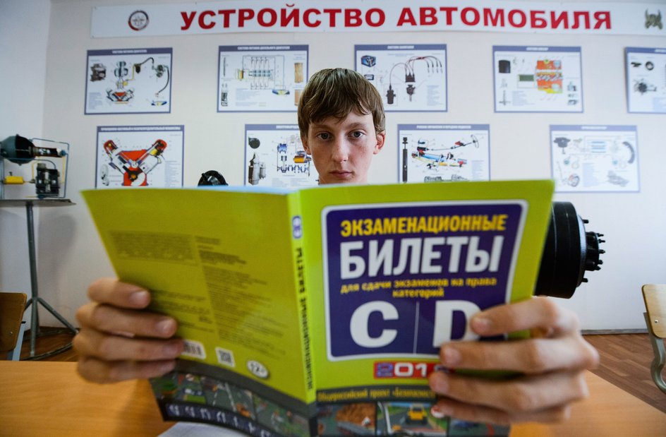 Ученик автошколы ДОСААФ на теоретическом занятии изучает билеты к экзамену на категорию C и D