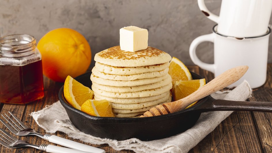 Пышные панкейки со сливочным маслом, фруктами на сковороде Пышные панкейки со сливочным маслом, фруктами на сковороде