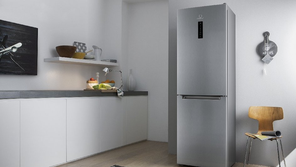 Серебристый холодильник стоит на фоне светлой кухни 