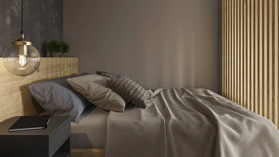 Двуспальная кровать с тёмным бельём на фоне коричневой стены