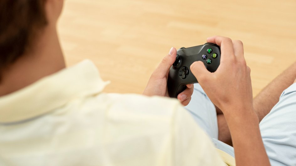 Мужчина держит в руках геймпад Xbox 360 Мужчина держит в руках геймпад Xbox 360