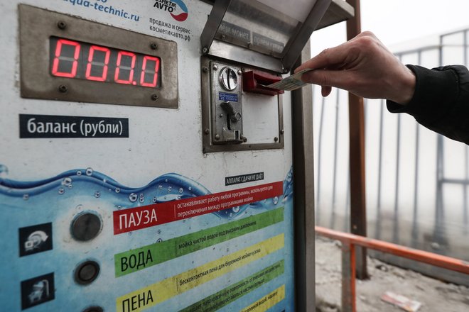 Мужчина оплачивает мойку самообслуживания Мужчина оплачивает мойку самообслуживания