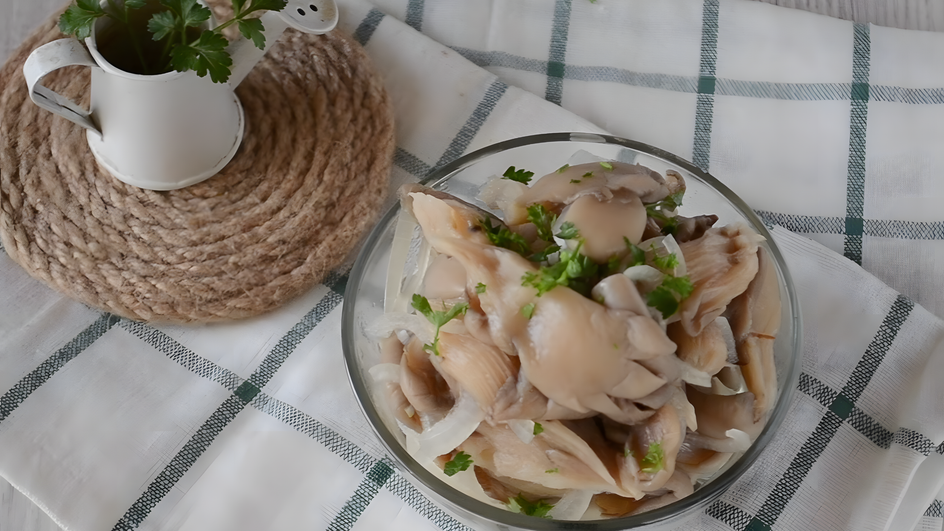Маринованные вешенки с луком и зеленью в тарелке Маринованные вешенки с луком и зеленью в тарелке