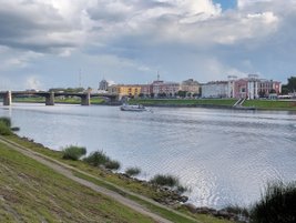 Берег реки, облака на небе, по реке плывет речной корабль