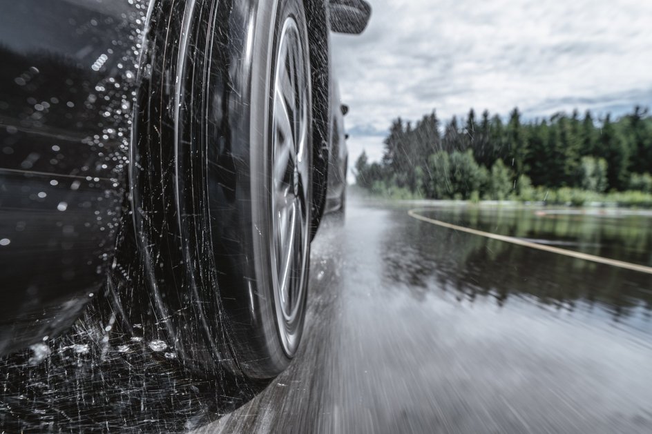 Автомобиль едет по мокрой дороге