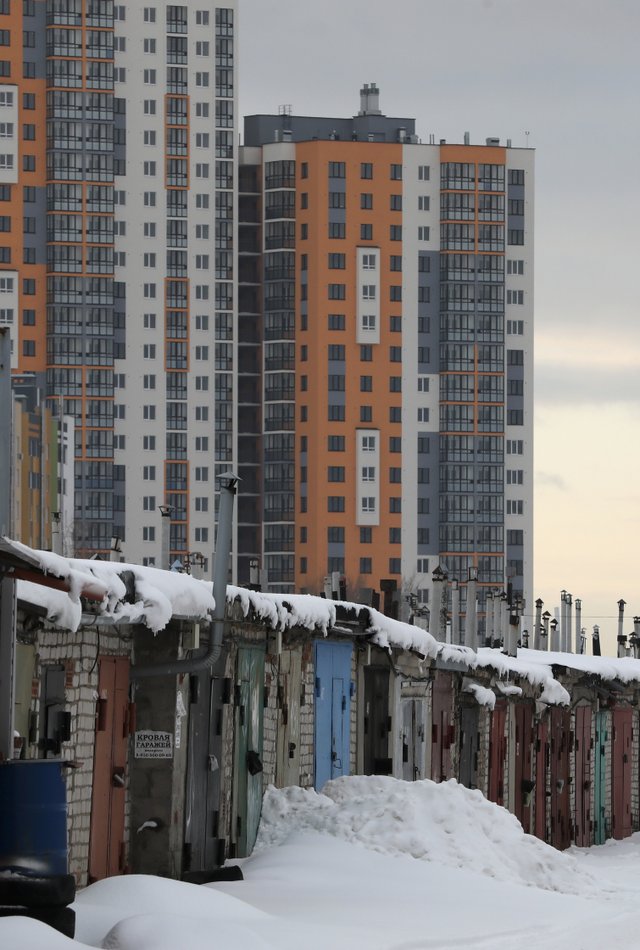 Гаражные постройки в одном из районов города на фоне высотных жилых домов