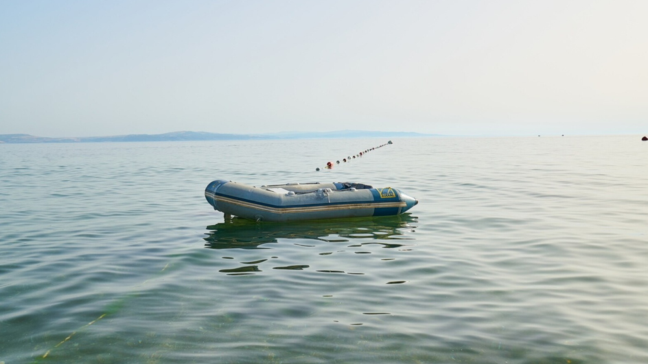 Лодка ПВХ на поверхности водоема Лодка ПВХ на поверхности водоема
