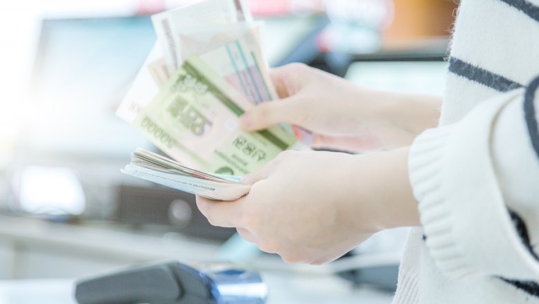 Женщина рассчитывается за товар. Женщина рассчитывается за товар.