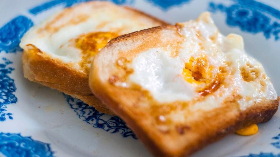 Гренки с чесноком и яйцом лежат на тарелке Гренки с чесноком и яйцом лежат на тарелке