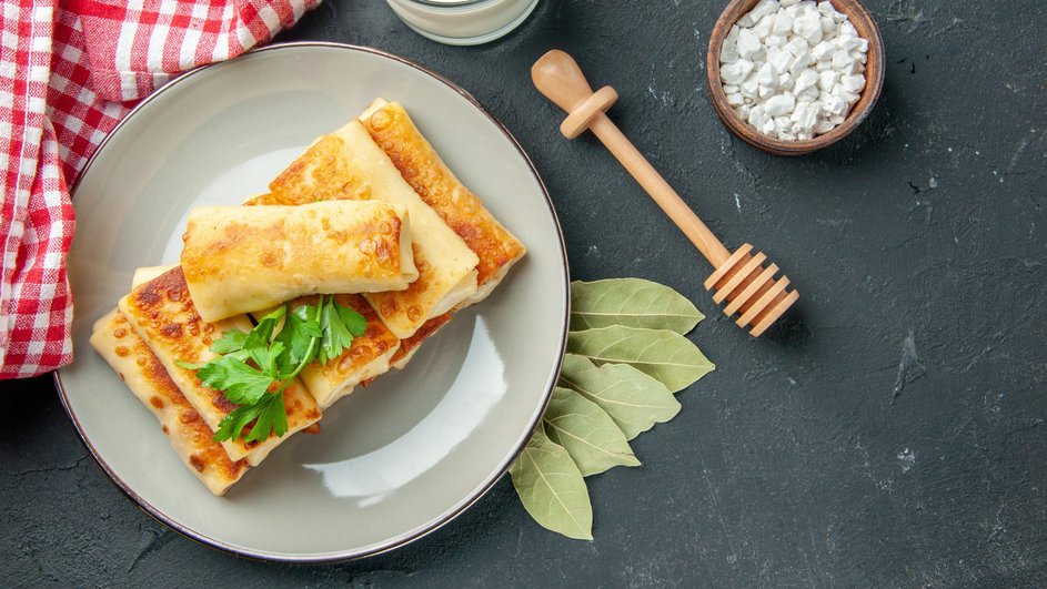 Блины с курицей и грибами лежат на тарелке Блины с курицей и грибами лежат на тарелке