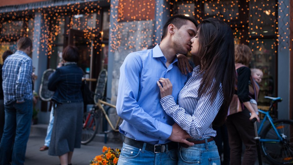 Парень-Телец целует девушку у ресторана