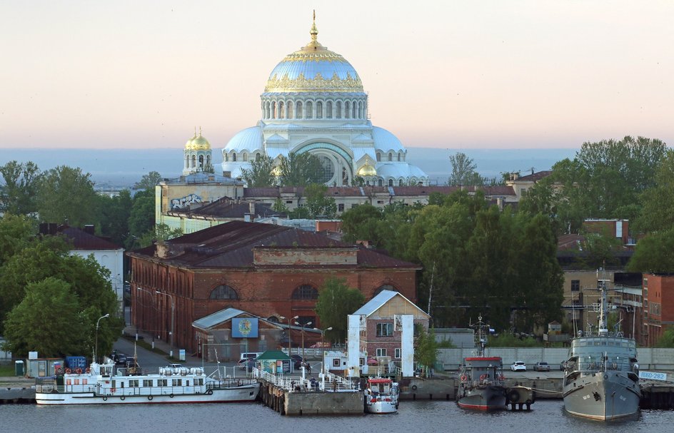 В гавани Кронштадта в Санкт-Петербурге пришвартованы исторические и современные военные и гражданские суда, на заднем плане возвышается Морской собор