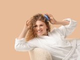 девушка расчесывает кудрявые волосы девушка расчесывает кудрявые волосы