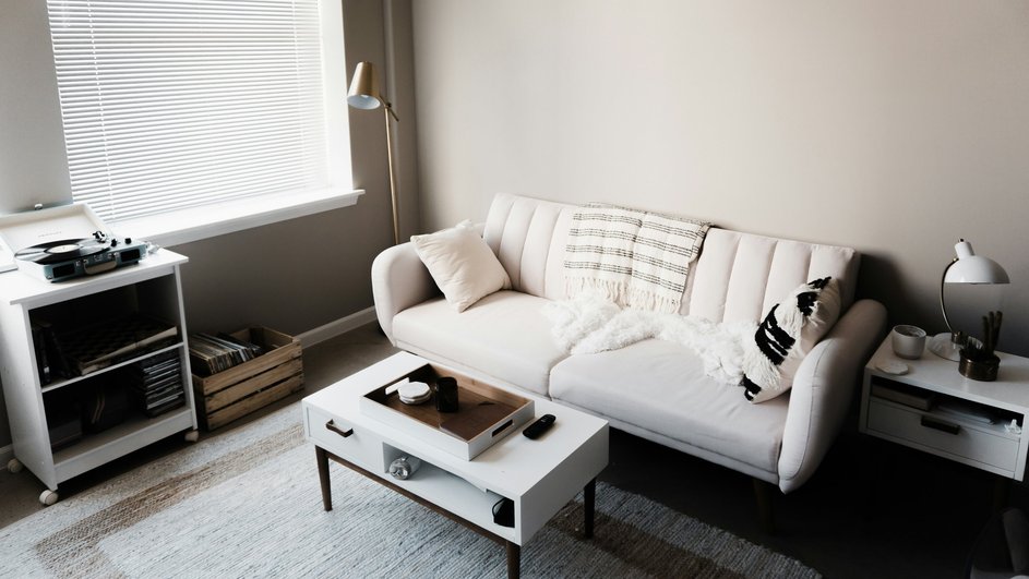 Чистая светлая комната с белым диваном