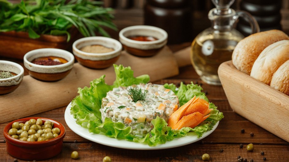 Салат с маринованными шампиньонами, бужениной и огурцами, украшенный зеленью, резной морковью и салатными листьями Салат с маринованными шампиньонами, бужениной и огурцами, украшенный зеленью, резной морковью и салатными листьями