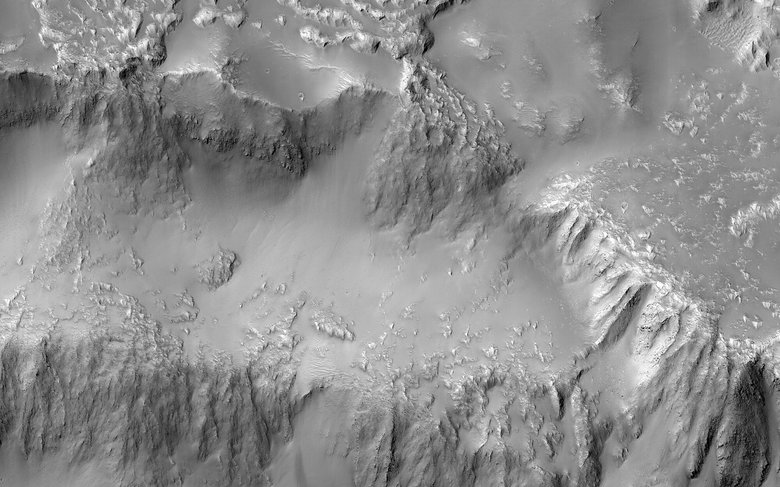 На снимке видно, как потоки лавы шли с северо-востока, наполняли кратер вулкана, а затем, переливаясь через край кратера, образовывали несколько потоков. Один из потоков лавы двигался в северо-западном направлении, а остальные три — в северном. В результате такого переливания и образовался «Ниагарский водопад», или квазикругловой поток, сообщает NASA. Ученые уверены, что в жидком состоянии лава вела себя на Марсе так же, как и вода. (Фото NASA)