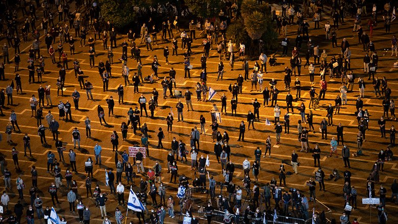 В разгар эпидемии в Тель-Авиве прошел митинг против политики премьера Нетаньяху. Собравшиеся держали дистанцию в 2 метра — получился почти перформанс