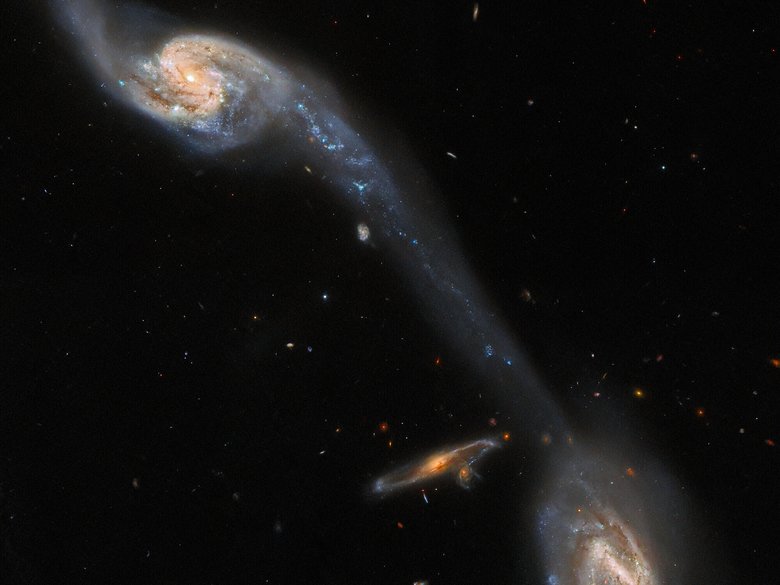 Галактики и светящаяся область между ними. Фото: ESA / Hubble & NASA