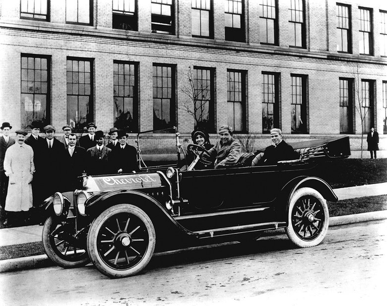 Первая серийная модель Chevrolet — Classic Six. Сам Луи Шевроле слева в белом пальто, Уильям Дюрант на заднем плане крайний справа. За рулем автомобиля сын основателя компании Клифф Дюрант