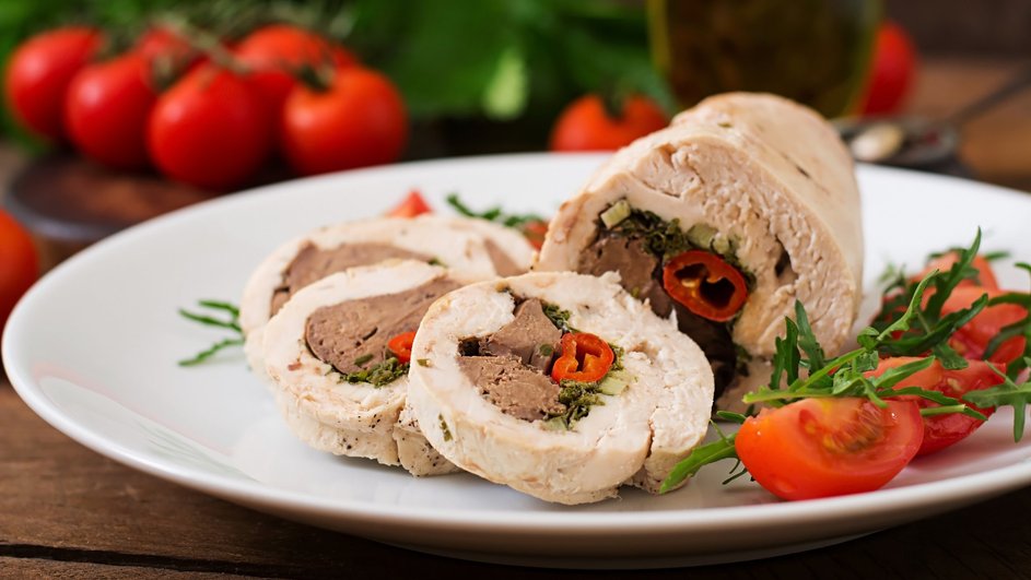 Куриный рулет лежит на тарелке Куриный рулет лежит на тарелке