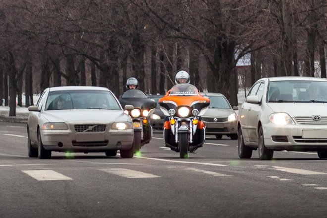 Мотоциклист между потоками автомобилей