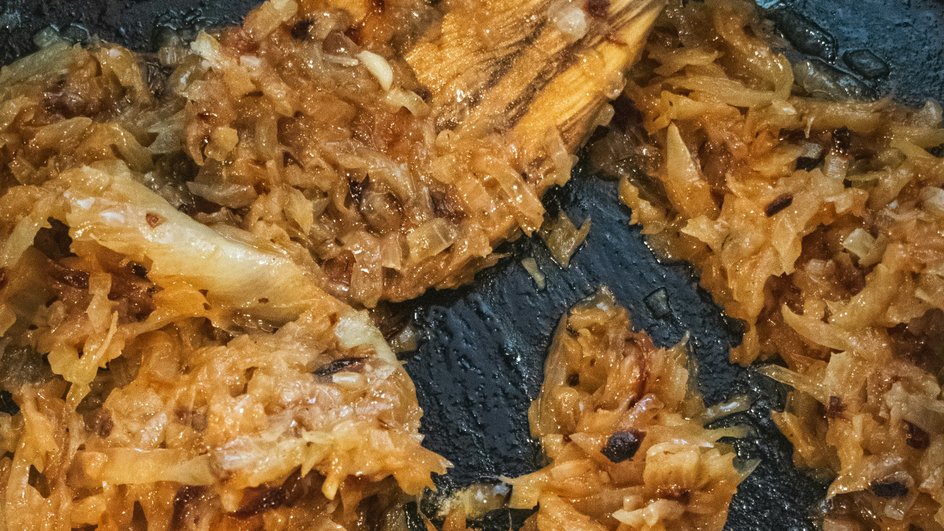 Карамелизованный лук готовится на сковороде Карамелизованный лук готовится на сковороде