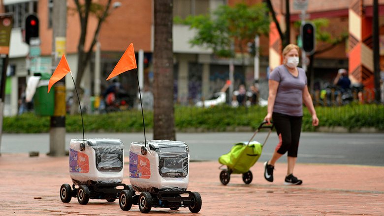 Роботы доставки путешествуют по улице в Медельине, Колумбия