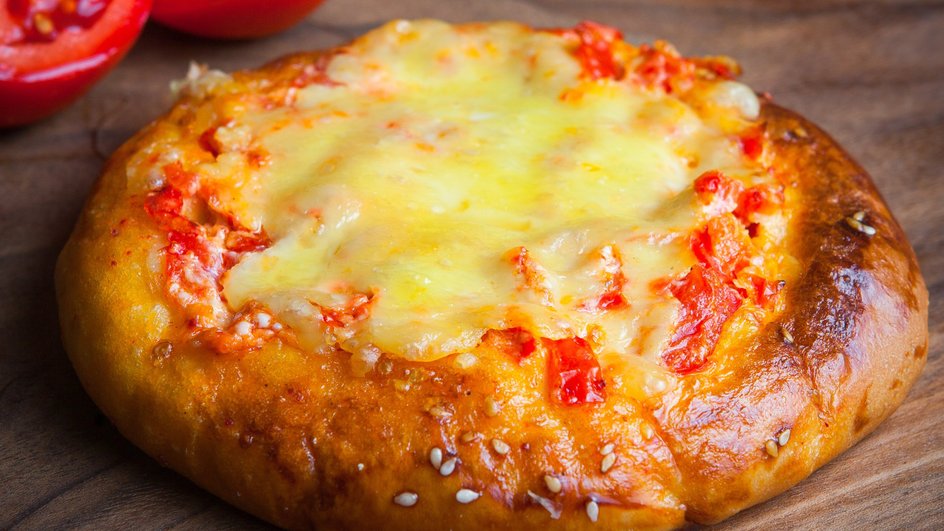 Ватрушка с сыром и томатами, приготовленная в духовке, крупным планом