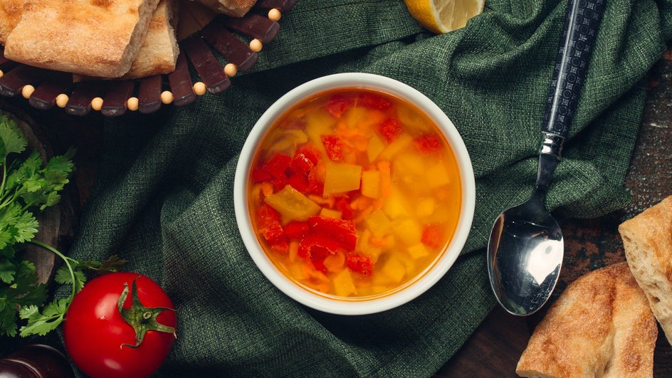 Тарелка супа минестроне с курицей стоит на столе Тарелка супа минестроне с курицей стоит на столе