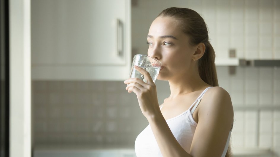 Девушка выпивает стакан воды