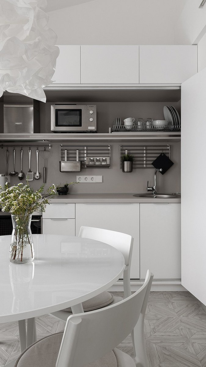 Квартира архитекторов: белый интерьер с кухней в шкафу и спальней на антресоли