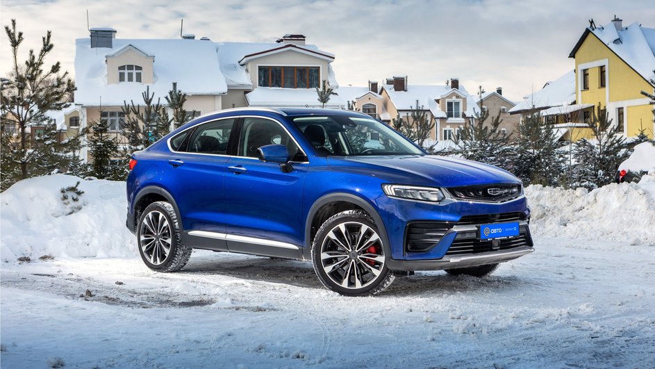 Кроссовер Geely Tugella запаркован на фоне заснеженного пейзажа поселка таун-хаусов Кроссовер Geely Tugella запаркован на фоне заснеженного пейзажа поселка таун-хаусов