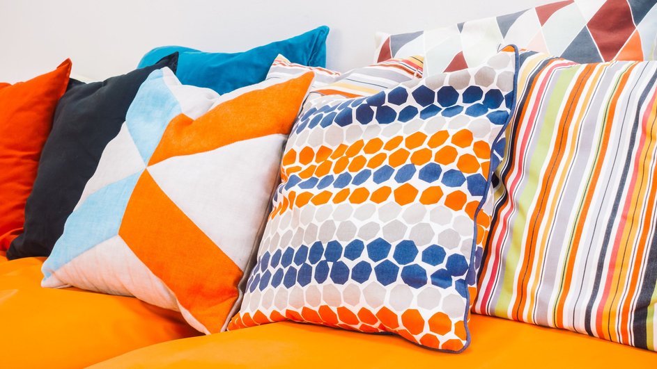Разноцветные подушки лежат на диване