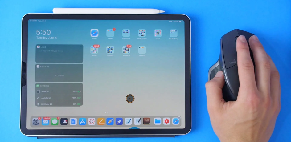 Подключенная к iPad беспроводная мышь в руке человека Подключенная к iPad беспроводная мышь в руке человека