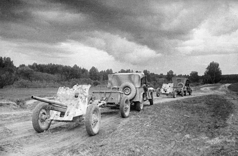 Машины ГАЗ-67 тянут по дороге артиллерийские орудия (1943 год). Фото © РИА «Новости»