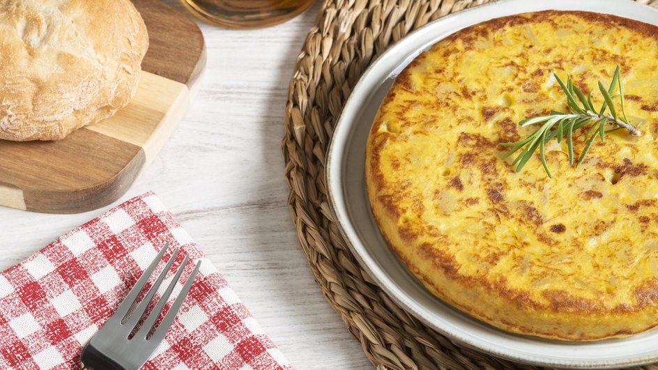 Заливной пирог из картофеля с грибами лежит на тарелке