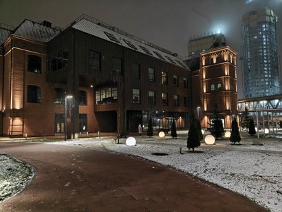 Красное трехэтажное здание в ночное время, с елочками и фонорями