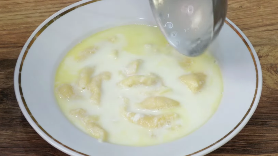 Тарелка молочного супа с клецками крупным планом Тарелка молочного супа с клецками крупным планом