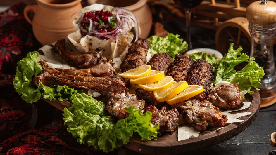 Свиной шашлык лежит на тарелке с дольками лимона