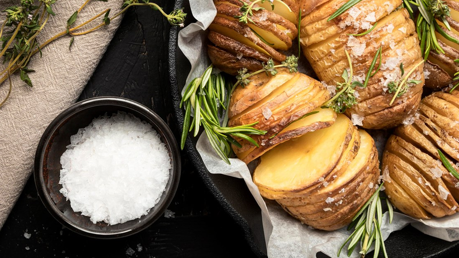 Запеченный картофель рядом с солью крупным планом Запеченный картофель рядом с солью крупным планом