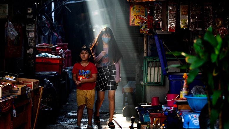 Люди в узком переулке в Бангкоке. Правительство Таиланда продолжает ослаблять ограничения на малые предприятия, которые были введены несколько недель назад для борьбы с распространением COVID-19.