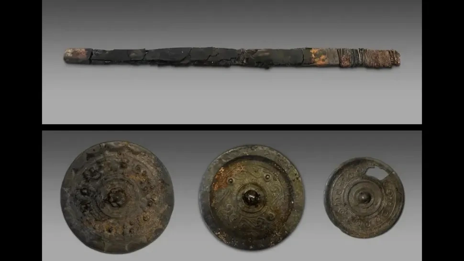Некоторые из артефактов, помещенных в качестве погребального инвентаря внутри гробниц, включают (вверху) лезвие железного меча, найденное в нетронутой гробнице, и (внизу) несколько бронзовых зеркал.