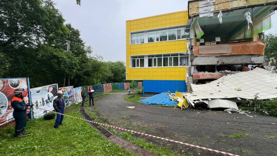 Спасатели на фоне разрушенного здания Спасатели на фоне разрушенного здания
