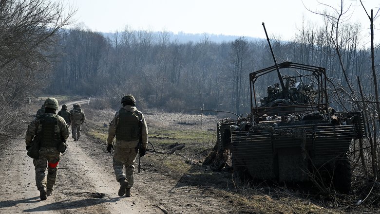 Военнослужащие РФ рядом со сгоревшим бронеавтомобилем ВСУ БТР-4 «Буцефал» на территории освобожденной деревни Новая Сорочина в Суджанском районе Курской области.