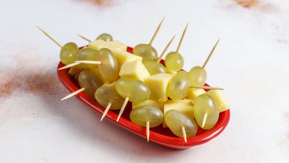 Канапе с виноградом и сыром лежит на тарелке
