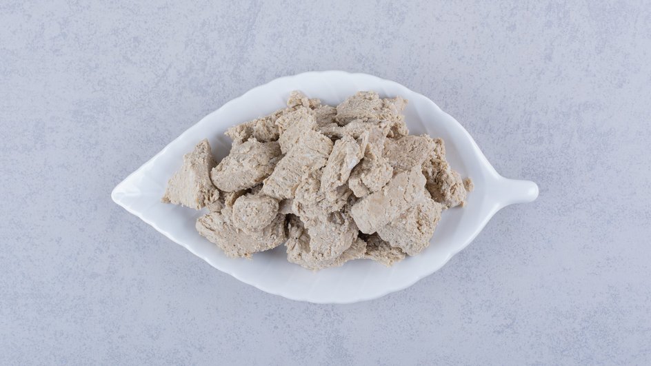 Кубики варенного куриного мяса для холодца из курицы с говядиной в мультиварке лежит на столе Кубики варенного куриного мяса для холодца из курицы с говядиной в мультиварке лежит на столе