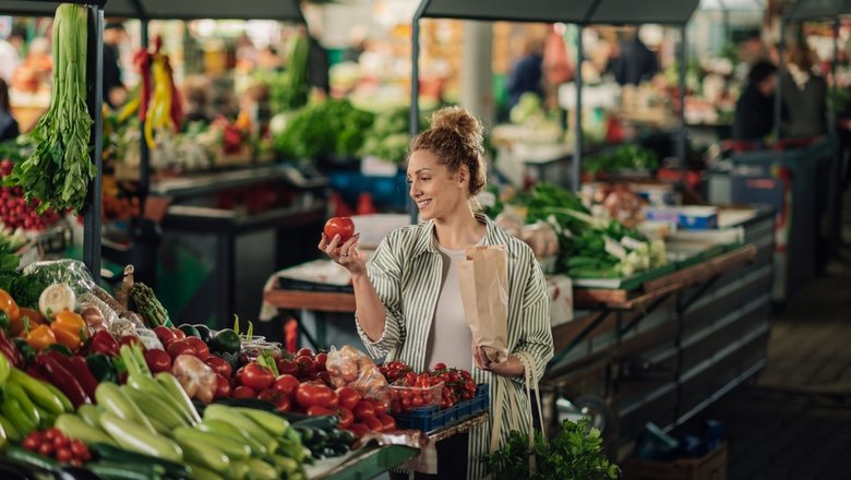 Девушка выбирает продукты питания на рынке на курорте.