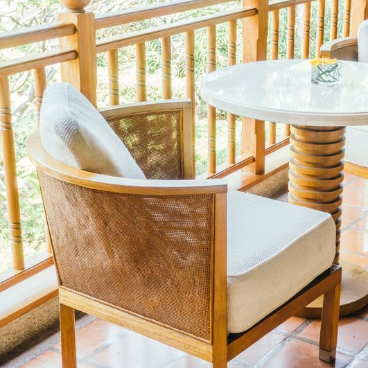 Летняя веранда для завтраков на балконе с креслами и столиком