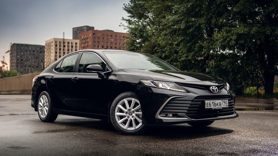 Черная Toyota Camry стоит на парковке у жилого комплекса